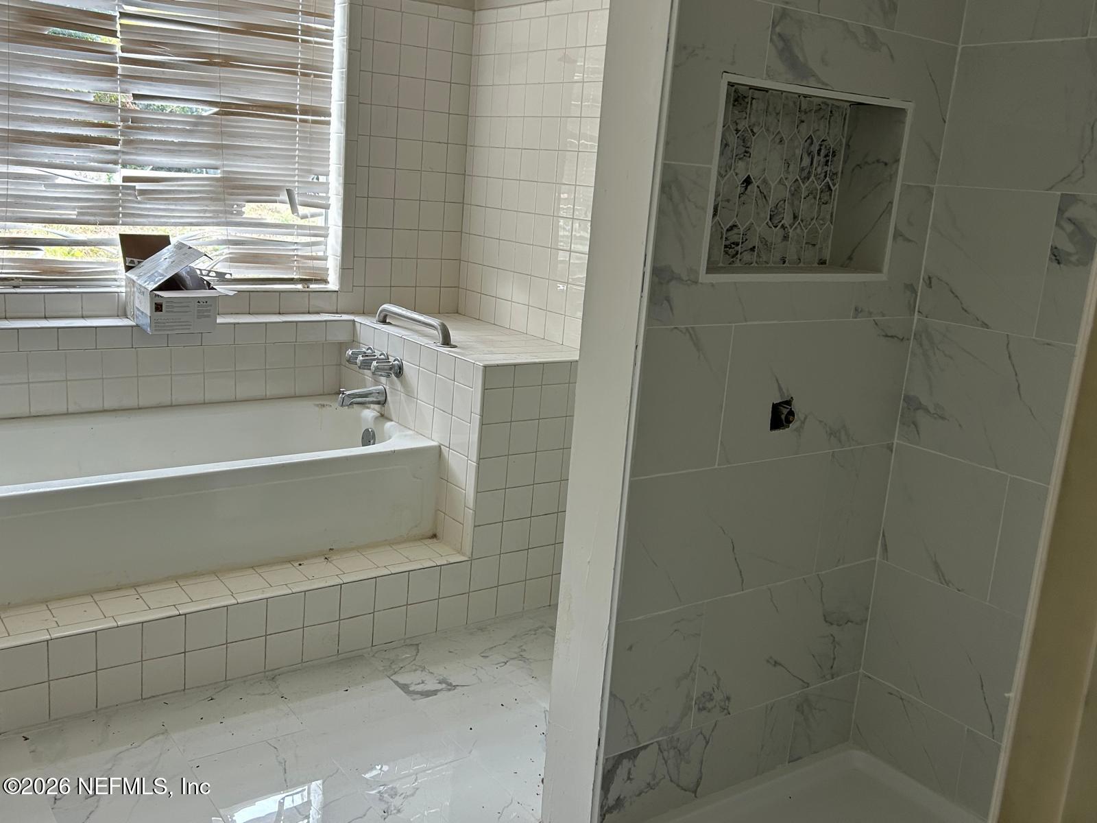 9959 Lem Turner Road Jacksonville, FL 32208 - Photo 13 of 22 a bathroom with a bathtub and a shower