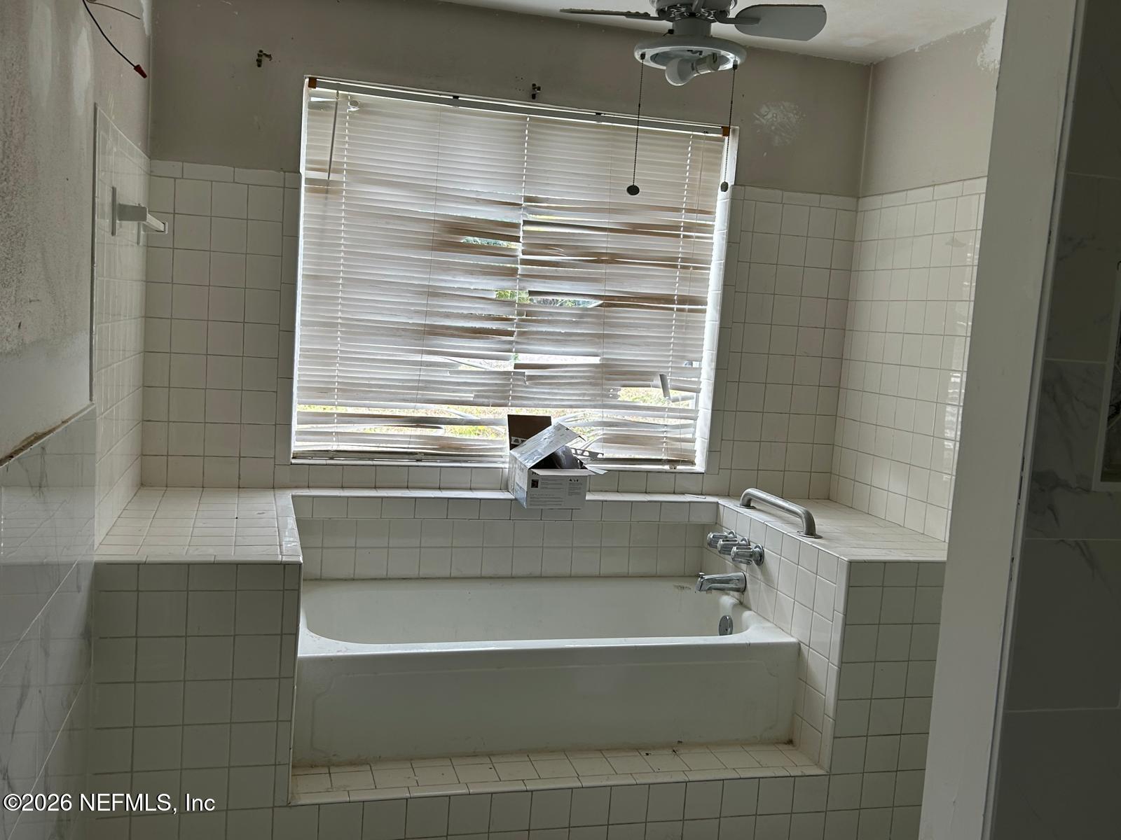 9959 Lem Turner Road Jacksonville, FL 32208 - Photo 14 of 22 a bathroom with a tub and shower
