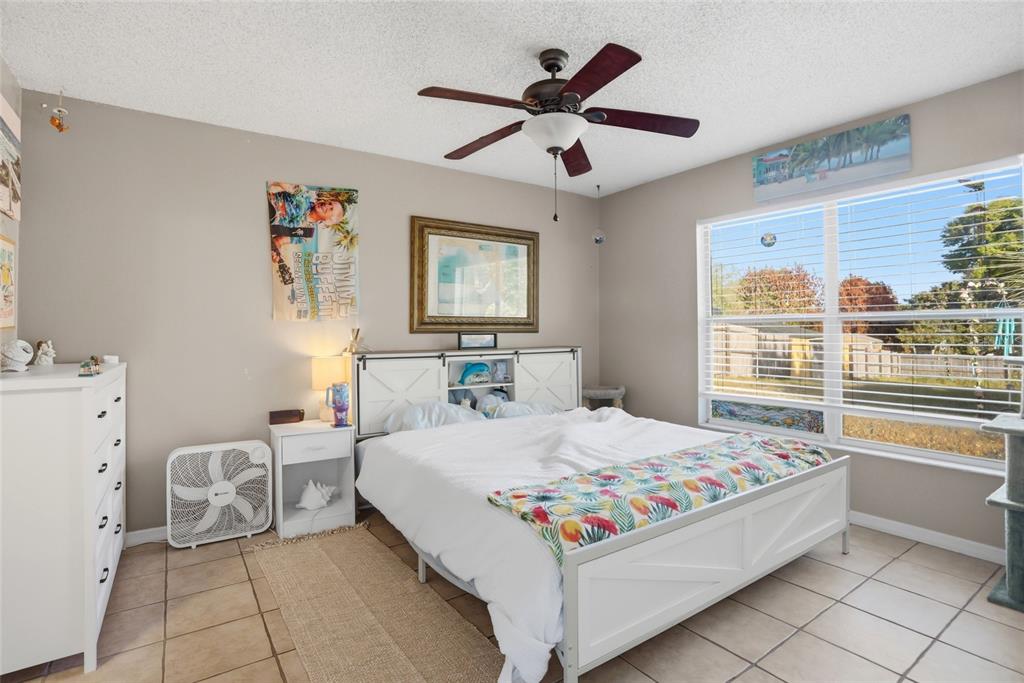 10735 Lake Ralph Drive Clermont, FL 34711 - Photo 14 of 37 a bedroom with a bed and a large window