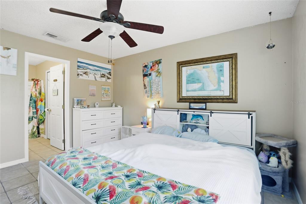 10735 Lake Ralph Drive Clermont, FL 34711 - Photo 15 of 37 a bedroom with a bed and a chandelier