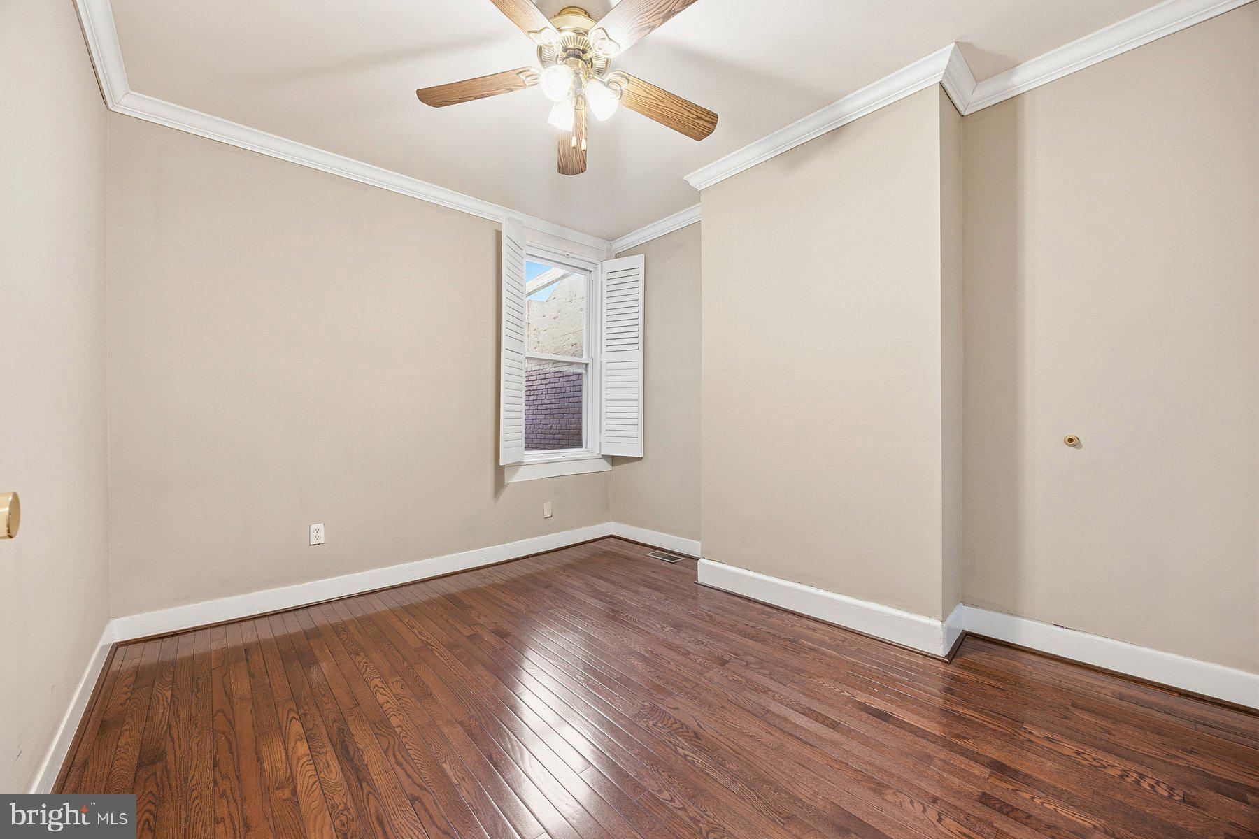 208 East Eager Street Baltimore, MD 21202 - Photo 15 of 31 an empty room with wooden floor chandelier fan and windows