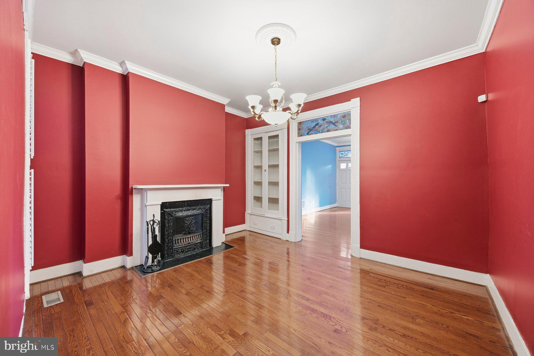 208 East Eager Street Baltimore, MD 21202 - Photo 4 of 31 a view of an empty room with wooden floor fireplace and a window