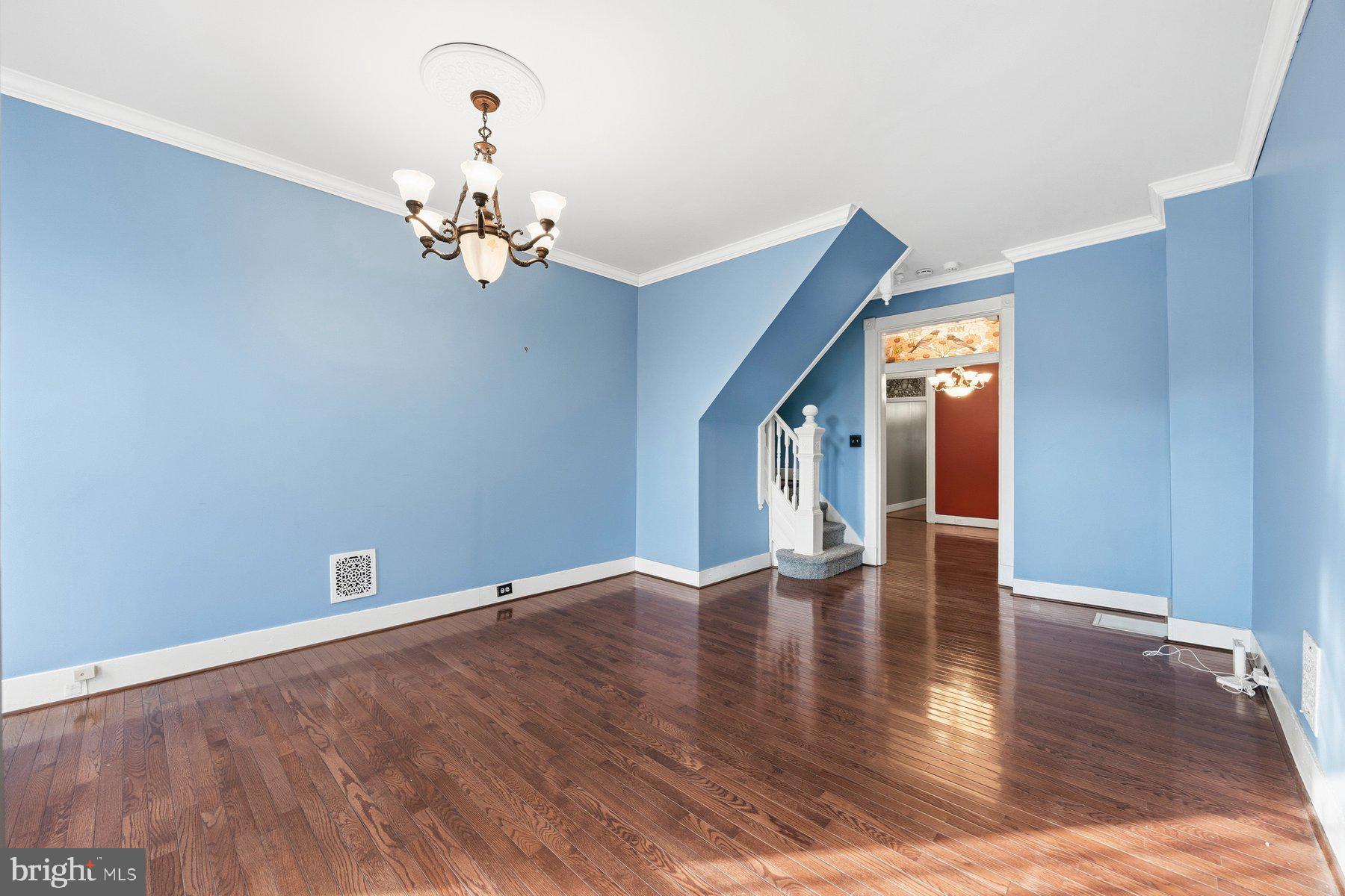 208 East Eager Street Baltimore, MD 21202 - Photo 7 of 31 a view of an empty room with chandelier and wooden floor
