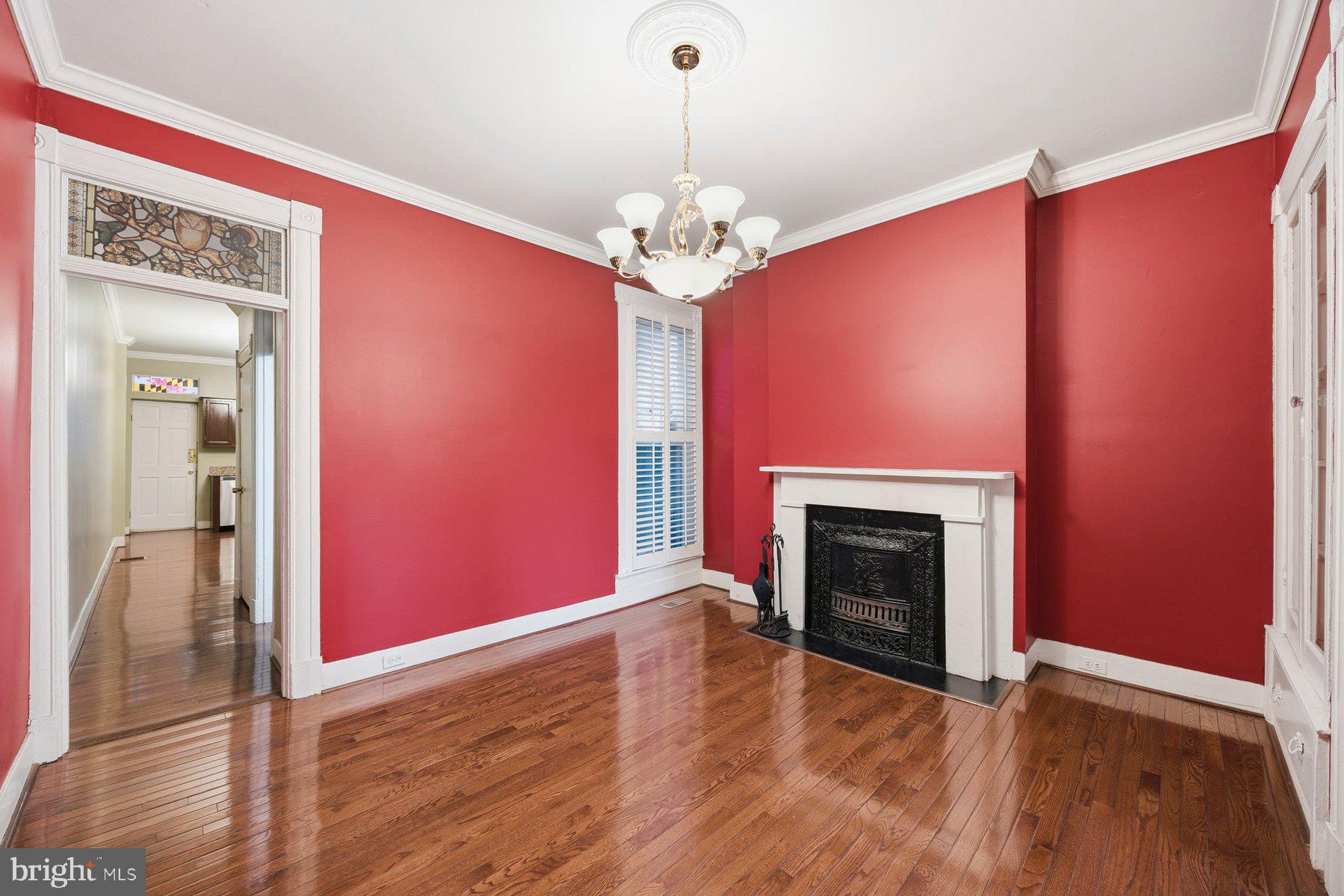 208 East Eager Street Baltimore, MD 21202 - Photo 8 of 31 a view of a livingroom with a fireplace wooden floor and chandelier