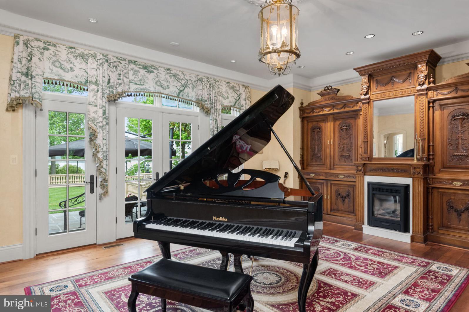 938 Old County Road Severna Park, MD 21146 - Photo 21 of 77 a living room with a piano a fireplace and a window