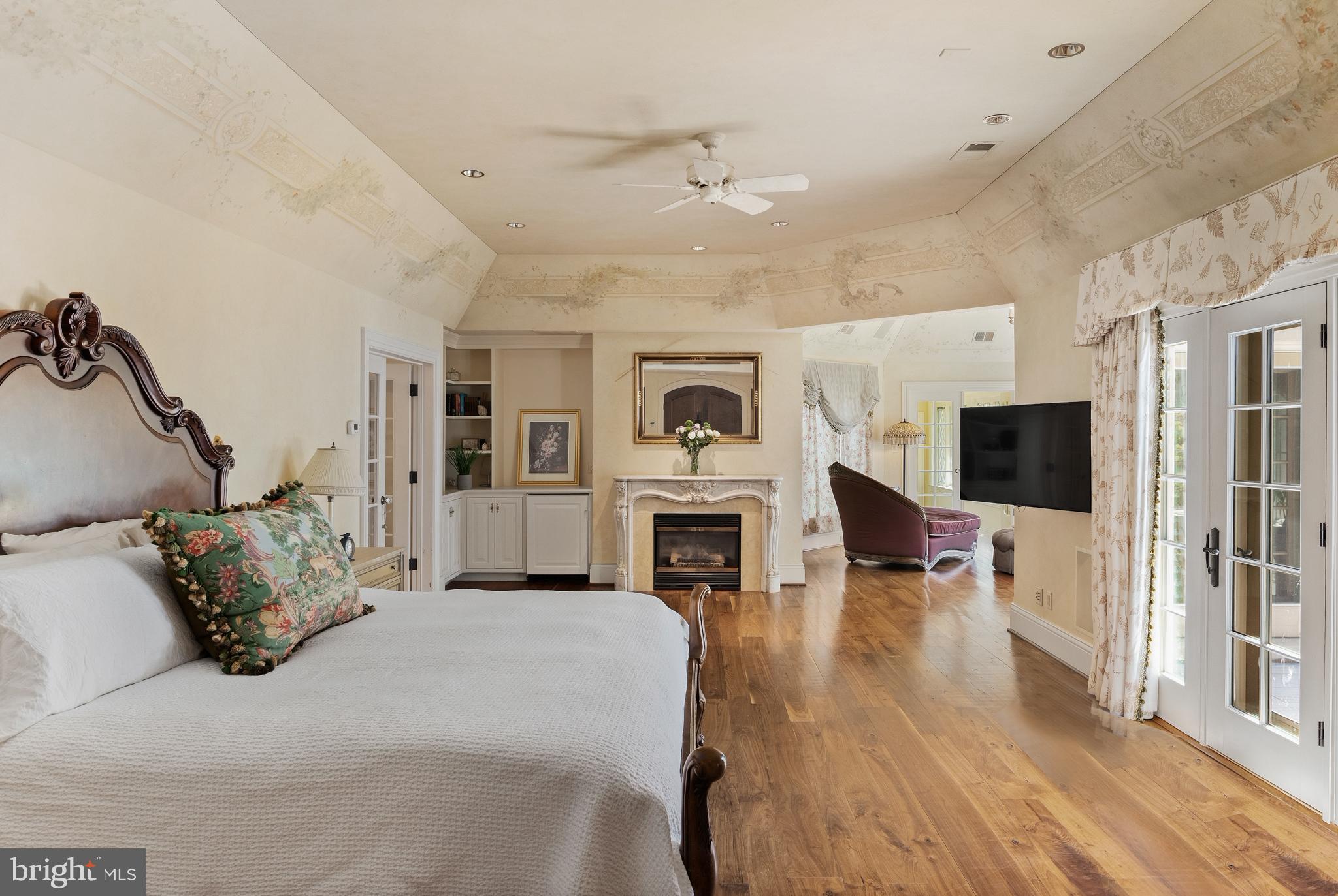 938 Old County Road Severna Park, MD 21146 - Photo 23 of 77 a spacious bedroom with a large bed a flat tv screen and a fireplace