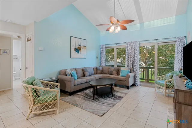 a living room with furniture a flat screen tv and a large window