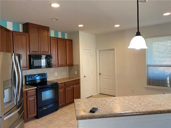 a kitchen with kitchen island granite countertop a sink stainless steel appliances and counter space