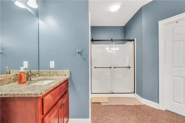 a bathroom with a granite countertop sink and shower