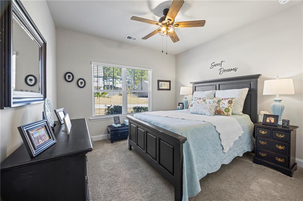 2347 Persimmon Chase Monroe, GA 30656 - Photo 17 of 85 a spacious bedroom with a bed a couch and a chandelier