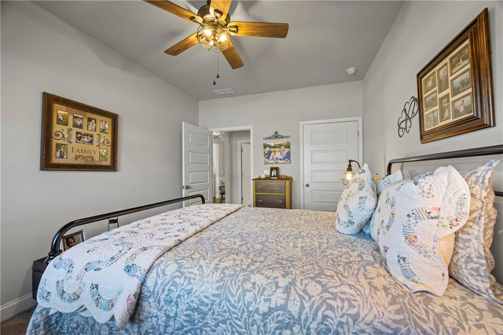 2347 Persimmon Chase Monroe, GA 30656 - Photo 23 of 85 a bedroom with a large bed and a chandelier