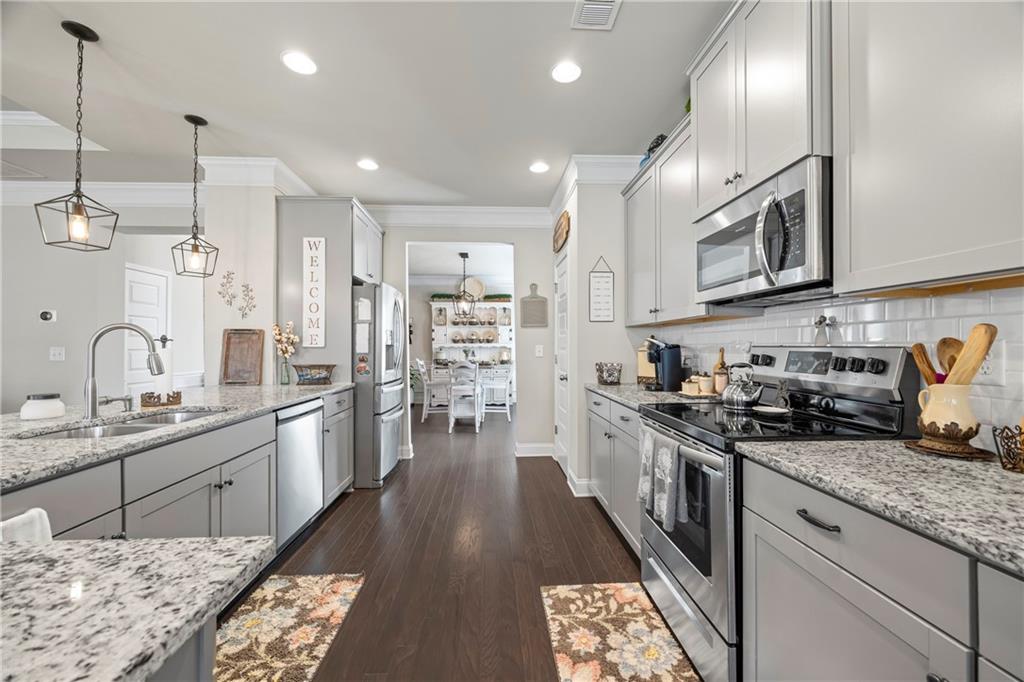2347 Persimmon Chase Monroe, GA 30656 - Photo 37 of 85 a kitchen with stainless steel appliances granite countertop a sink stove and refrigerator