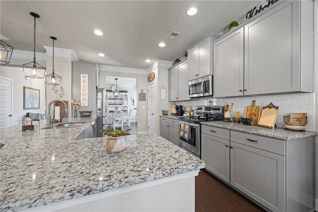 2347 Persimmon Chase Monroe, GA 30656 - Photo 39 of 85 a kitchen with stainless steel appliances granite countertop a sink stove and refrigerator