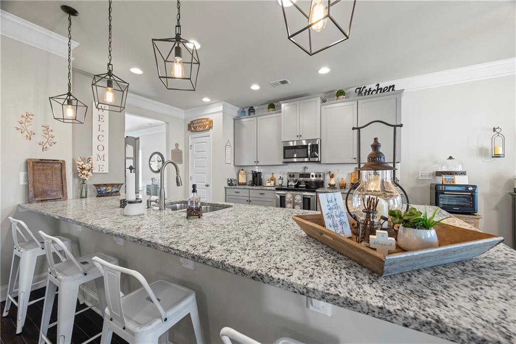 2347 Persimmon Chase Monroe, GA 30656 - Photo 40 of 85 a view of a kitchen with kitchen island a sink and a view of living room