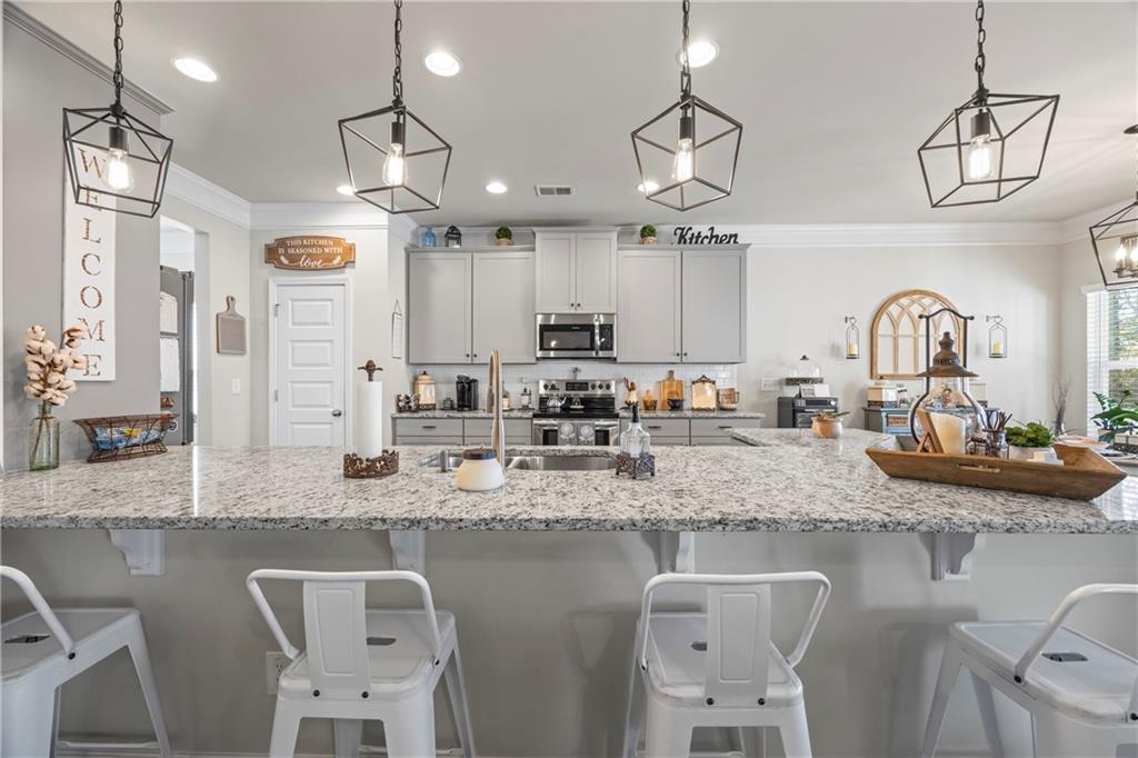 2347 Persimmon Chase Monroe, GA 30656 - Photo 41 of 85 a kitchen with stainless steel appliances granite countertop a sink a stove and a refrigerator