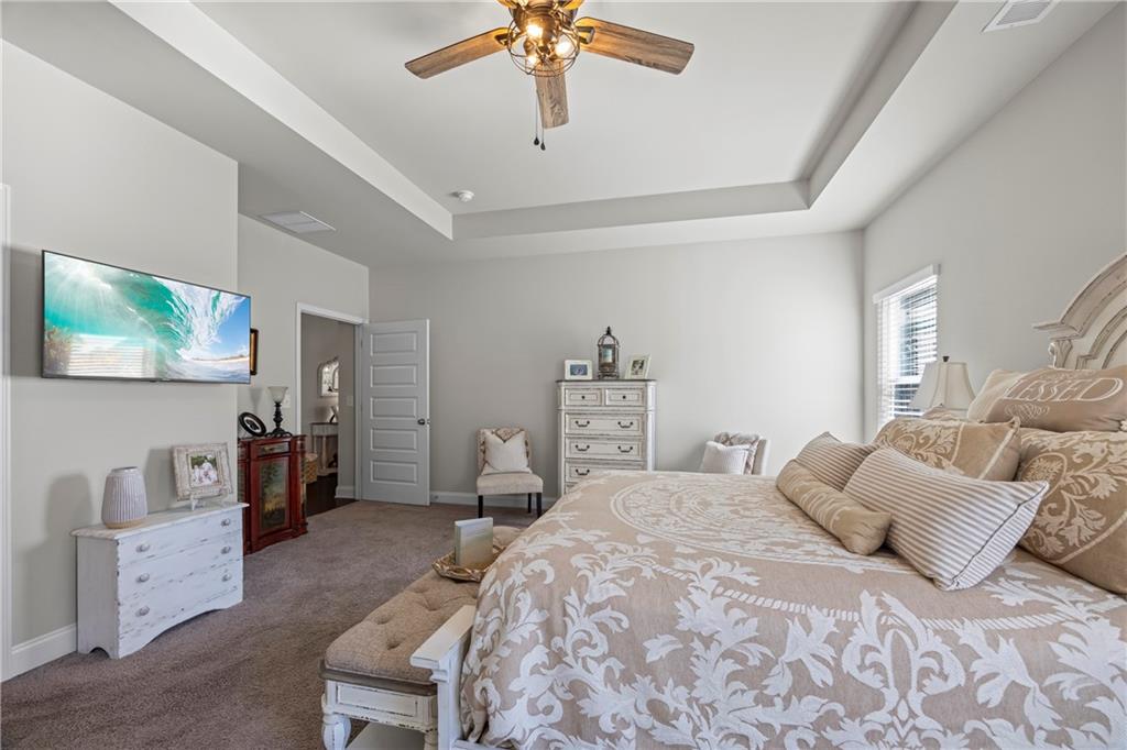 2347 Persimmon Chase Monroe, GA 30656 - Photo 67 of 85 a bedroom with a large bed and a chandelier