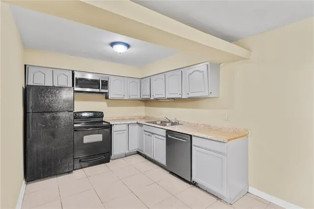 a kitchen with stainless steel appliances granite countertop a refrigerator sink and stove