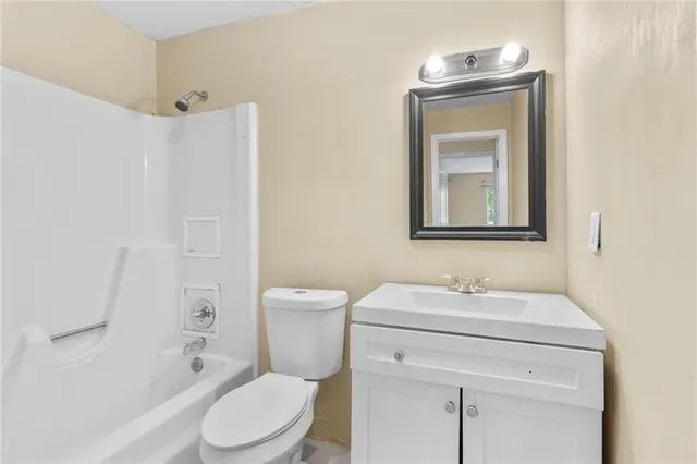 a bathroom with a toilet sink vanity and mirror