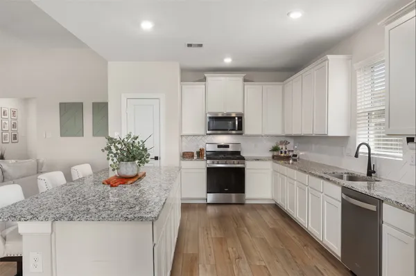 a kitchen with granite countertop a sink stove and cabinets