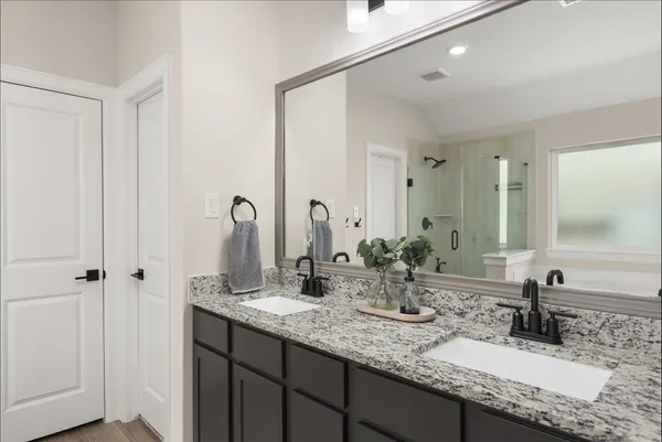 a bathroom with double vanity sinks and a mirror