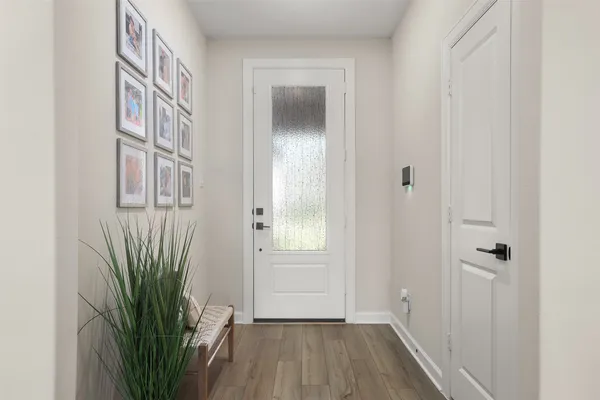 a view of a hallway with wooden floor and a livingroom