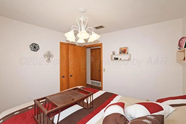 a bedroom with a bed and a chandelier