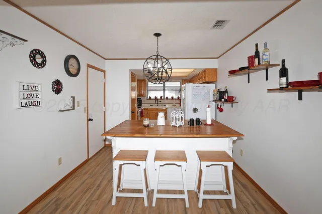 a dining room with furniture a chandelier and wooden floor