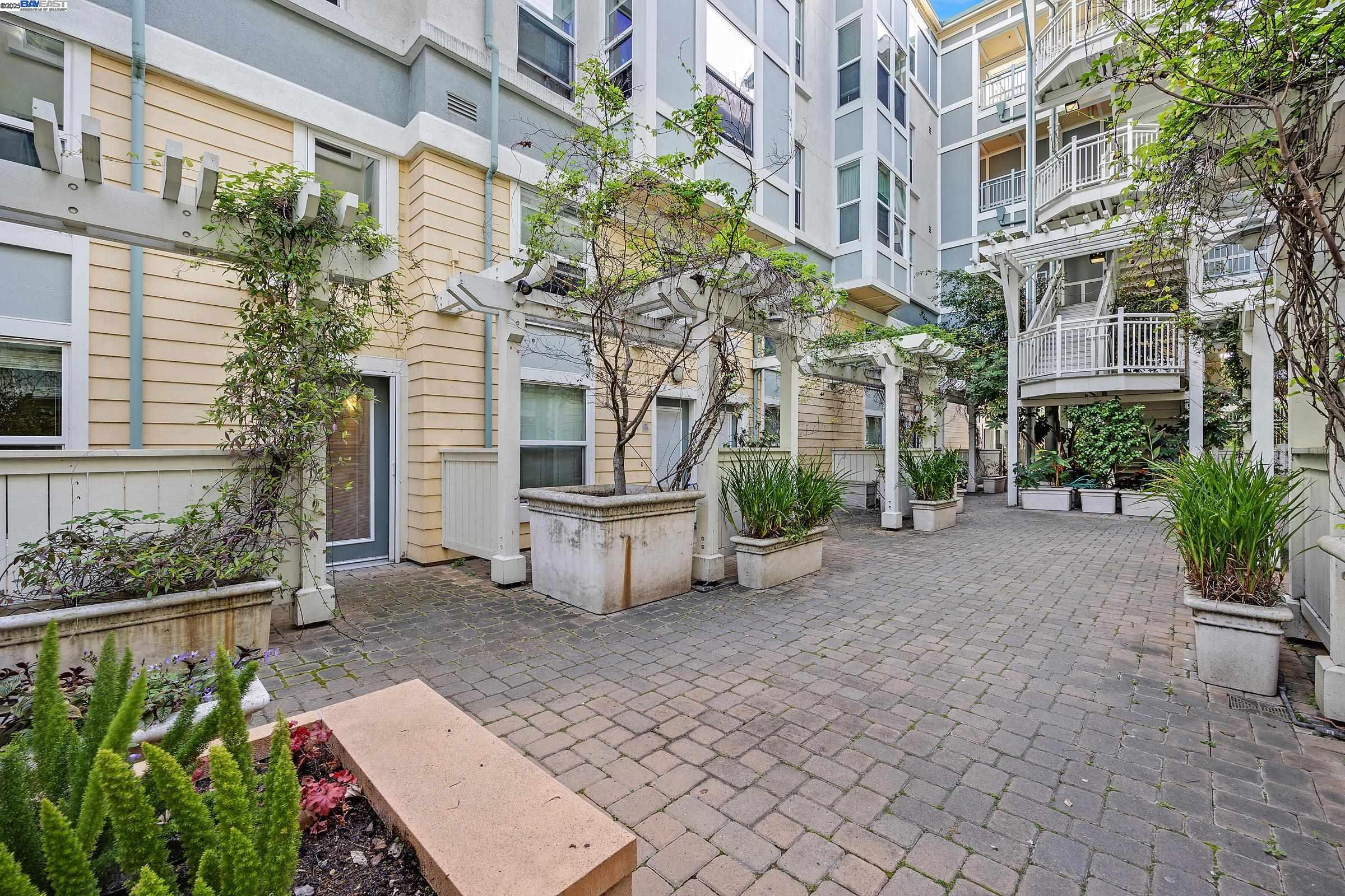 a view of a building with potted plants and a bench
