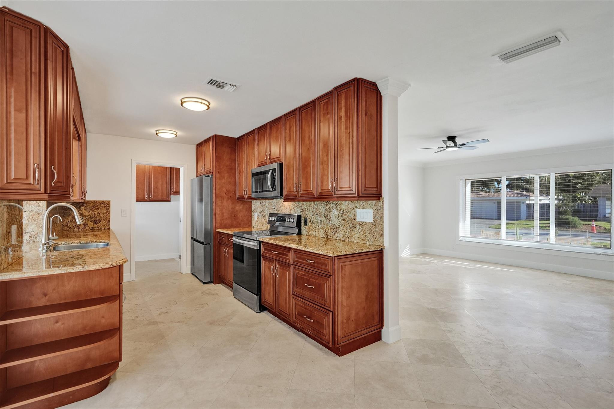 2011 Northeast 34th Street Lighthouse Point, FL 33064 - Photo 15 of 47 a kitchen with stainless steel appliances granite countertop a stove refrigerator and cabinets