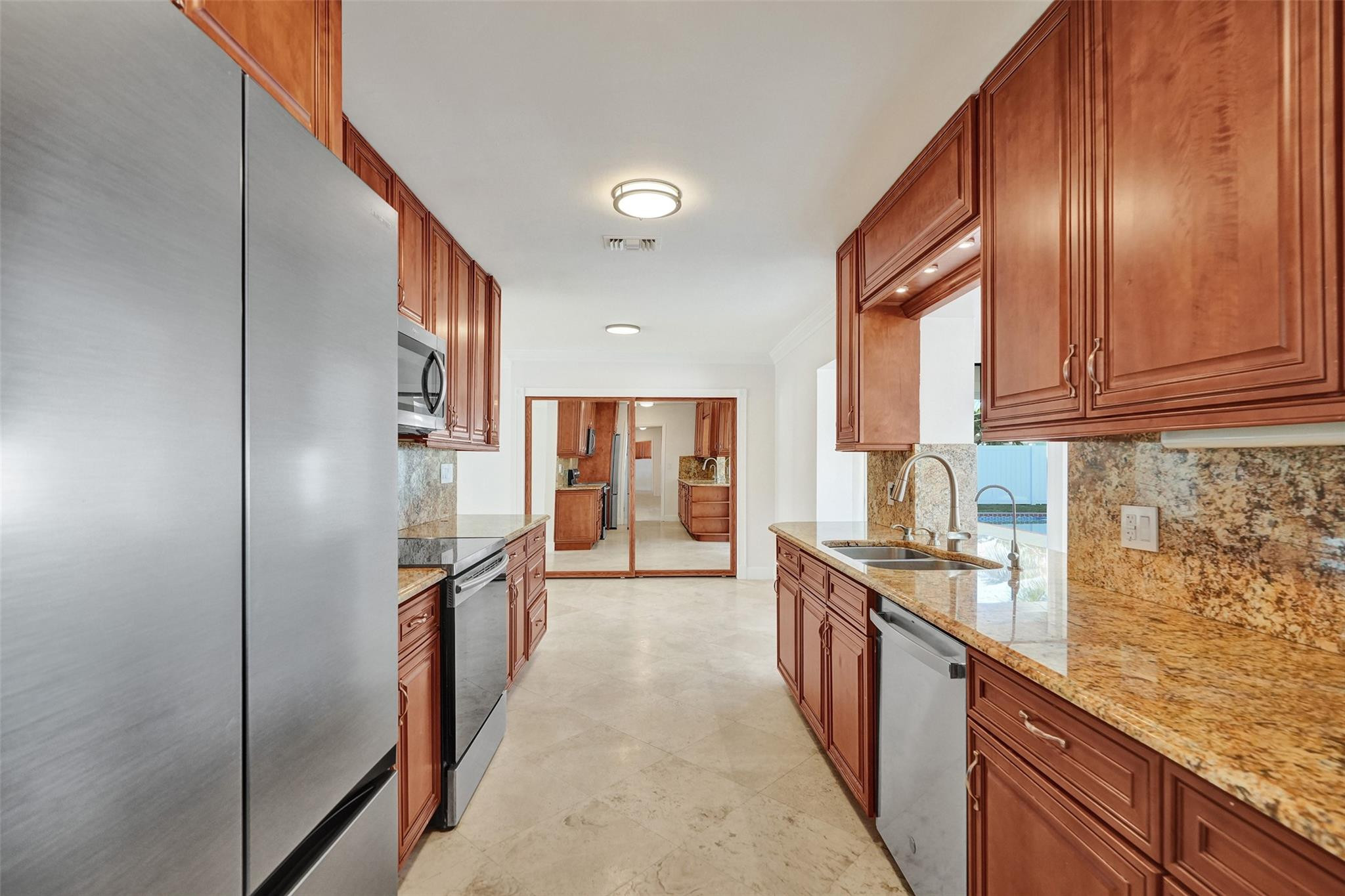2011 Northeast 34th Street Lighthouse Point, FL 33064 - Photo 17 of 47 a kitchen with stainless steel appliances granite countertop a refrigerator and wooden cabinets
