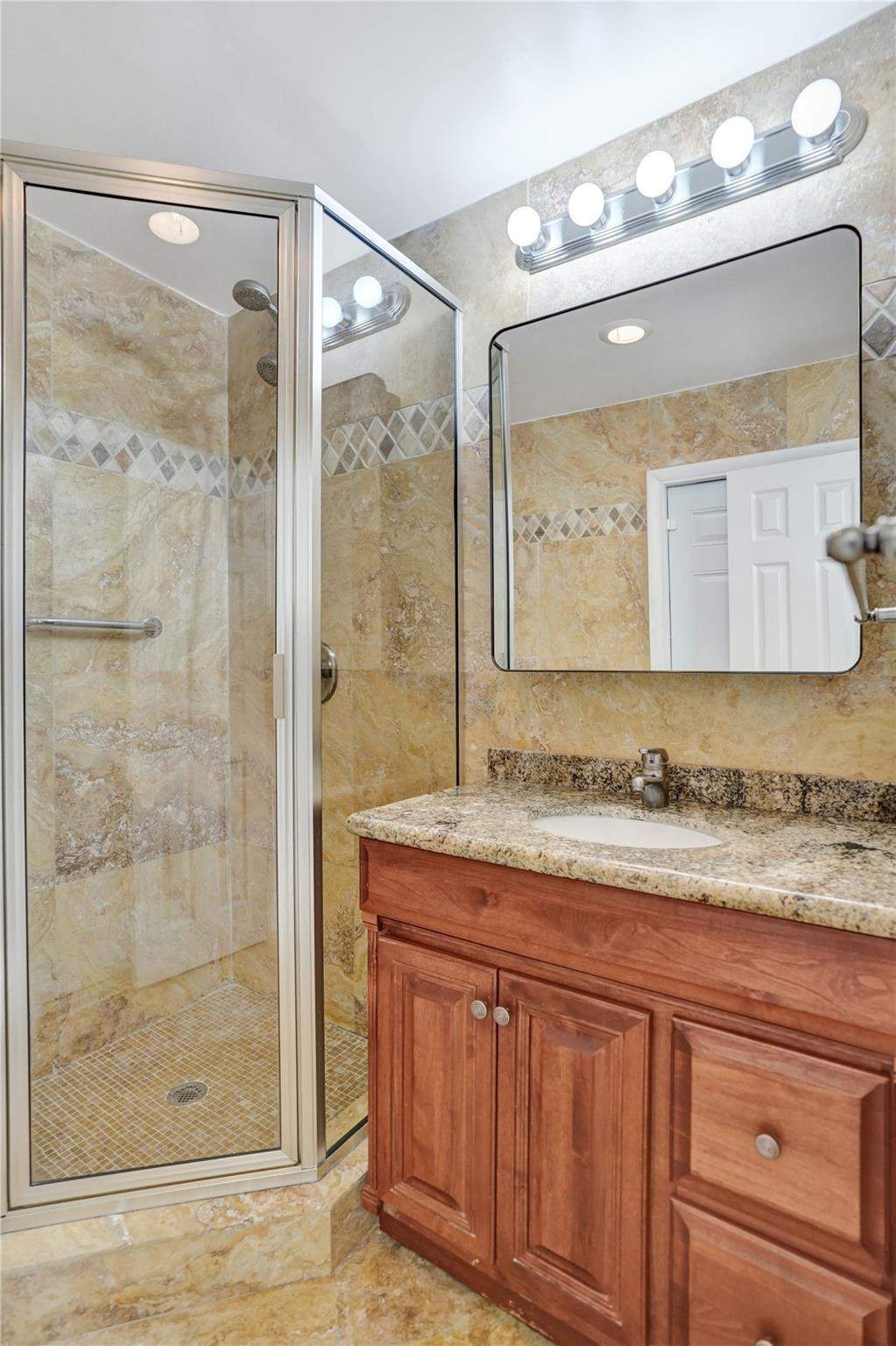 2011 Northeast 34th Street Lighthouse Point, FL 33064 - Photo 29 of 47 a bathroom with a granite countertop sink mirror and a shower