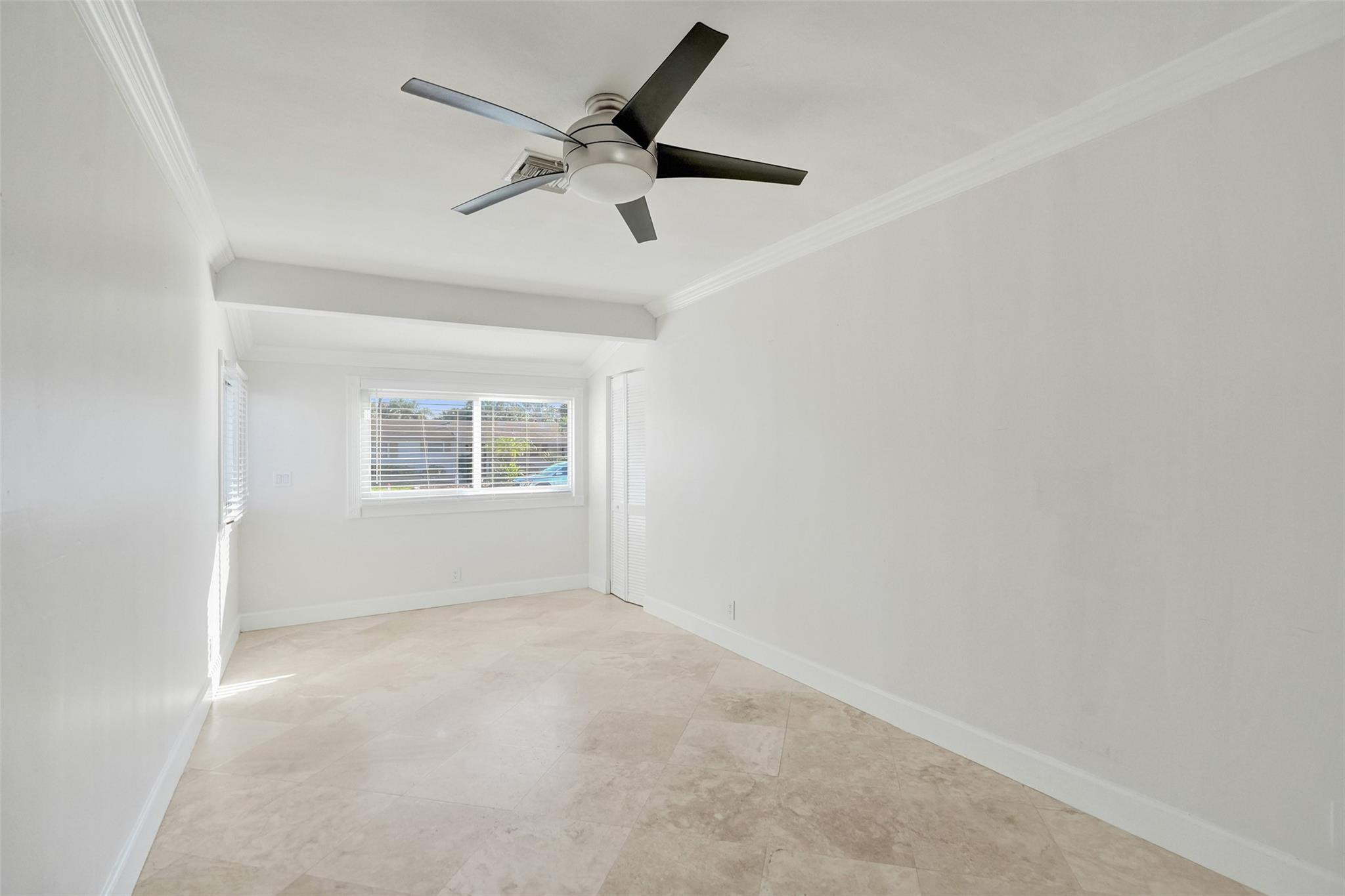 2011 Northeast 34th Street Lighthouse Point, FL 33064 - Photo 40 of 47 an empty room with a window and a ceiling fan