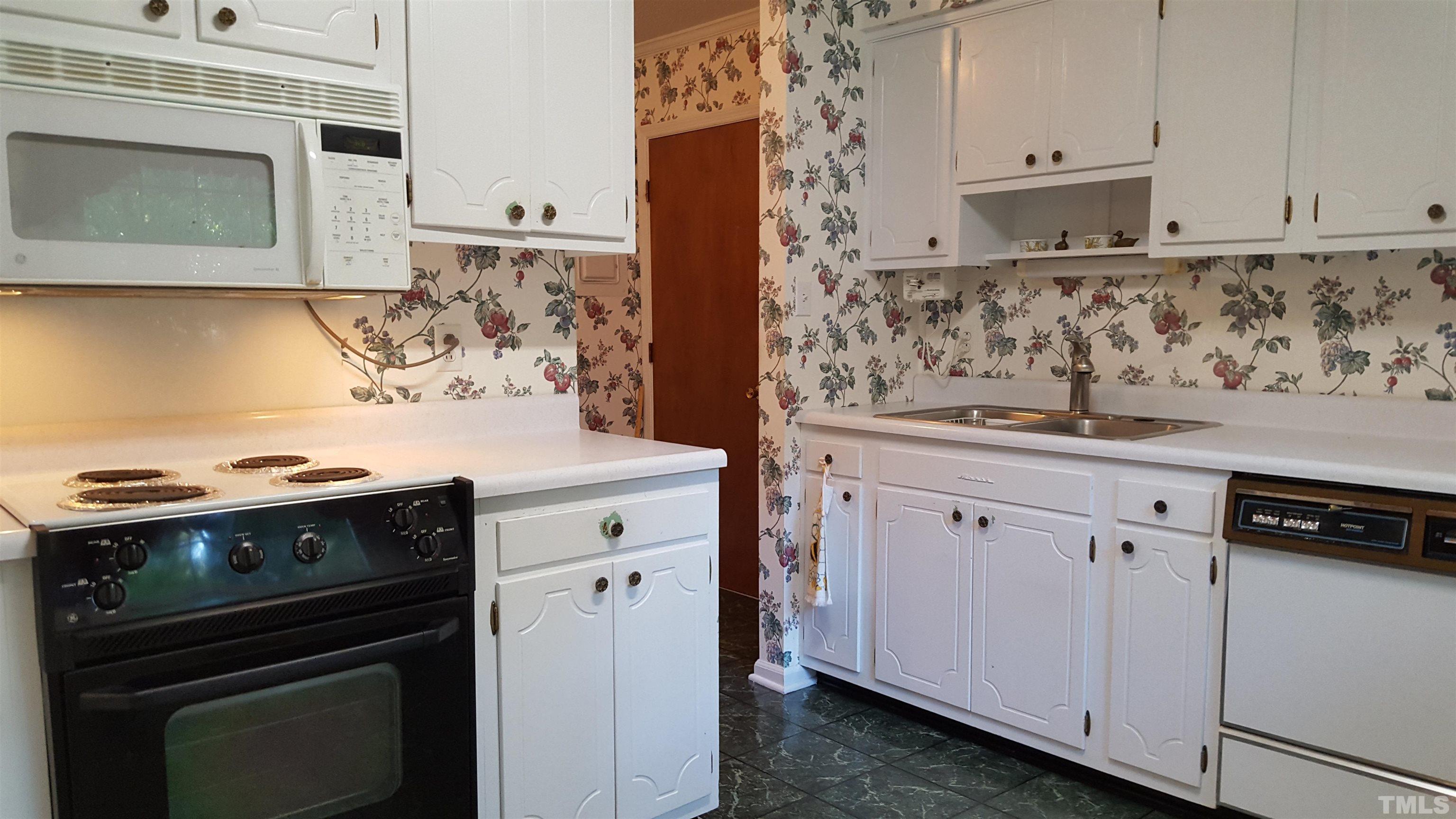 212 Longview Drive Smithfield, NC 27577 - Photo 10 of 15 a kitchen with granite countertop white cabinets and black appliances