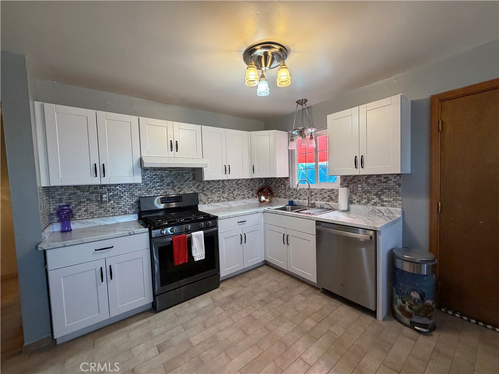 25478 Ash Road Barstow, CA 92311 - Photo 21 of 35 a kitchen with a sink stove and white cabinets