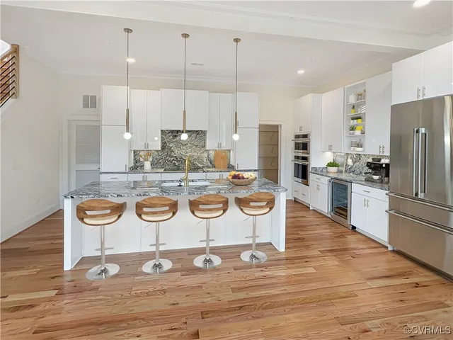 a kitchen with stainless steel appliances granite countertop a stove a refrigerator and a wooden cabinets