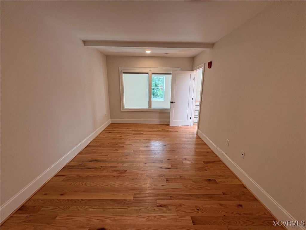 3215 Stuart Avenue, Unit 30 Richmond, VA 23221 - Photo 22 of 28 a view of an empty room with wooden floor and a window