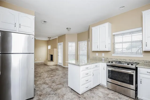 a kitchen with white cabinets and white appliances