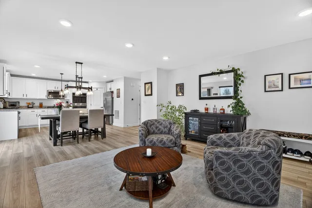 a living room with furniture and a view of kitchen