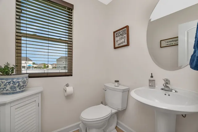 a bathroom with a toilet a sink and mirror