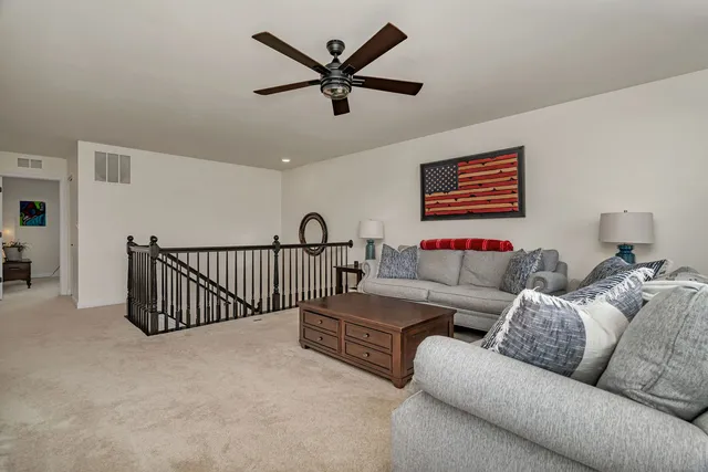 a living room with furniture ceiling fan and a window
