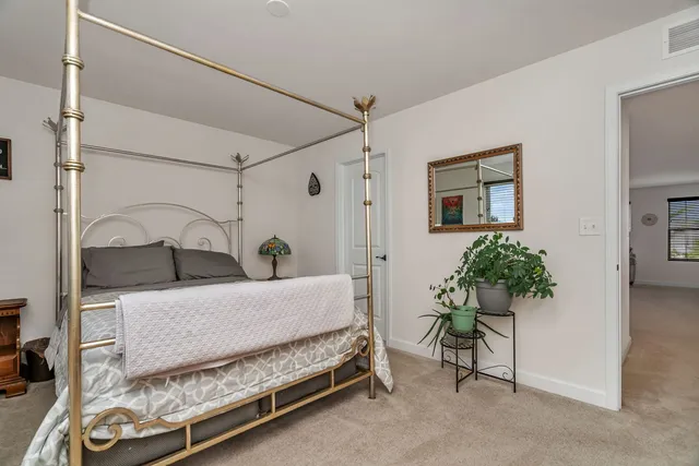 a bedroom with a bed and a potted plant