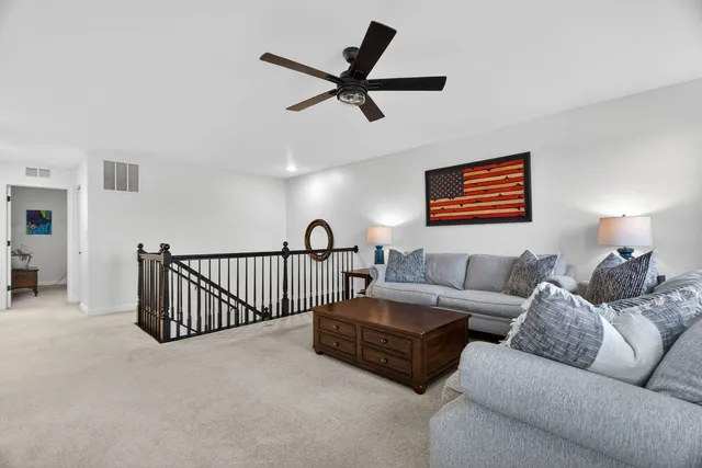 a living room with furniture and a ceiling fan