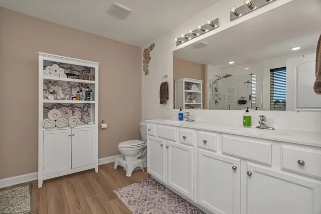 a spacious bathroom with a toilet a sink a mirror and vanity