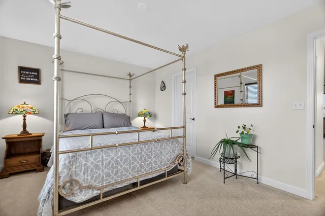 a bedroom with a bed lamp and paintings on the wall