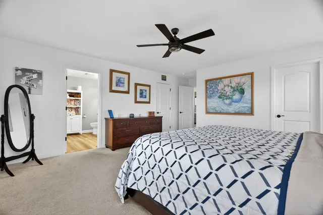 a bedroom with a bed and dresser with mirror