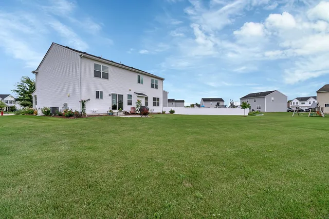 a view of a house with a big yard and sitting area