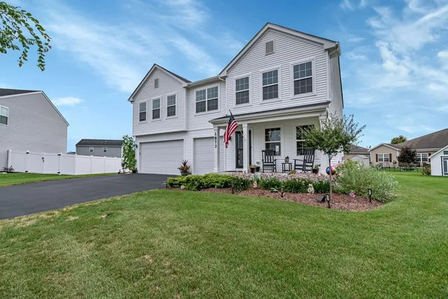 a front view of a house with a garden and plants