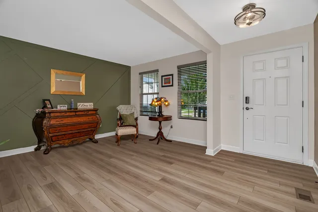 a living room with furniture a piano and a window