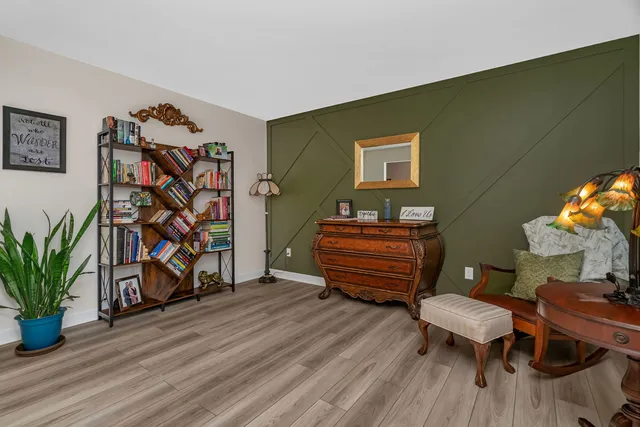 a room with wooden floor stairs and a potted plant