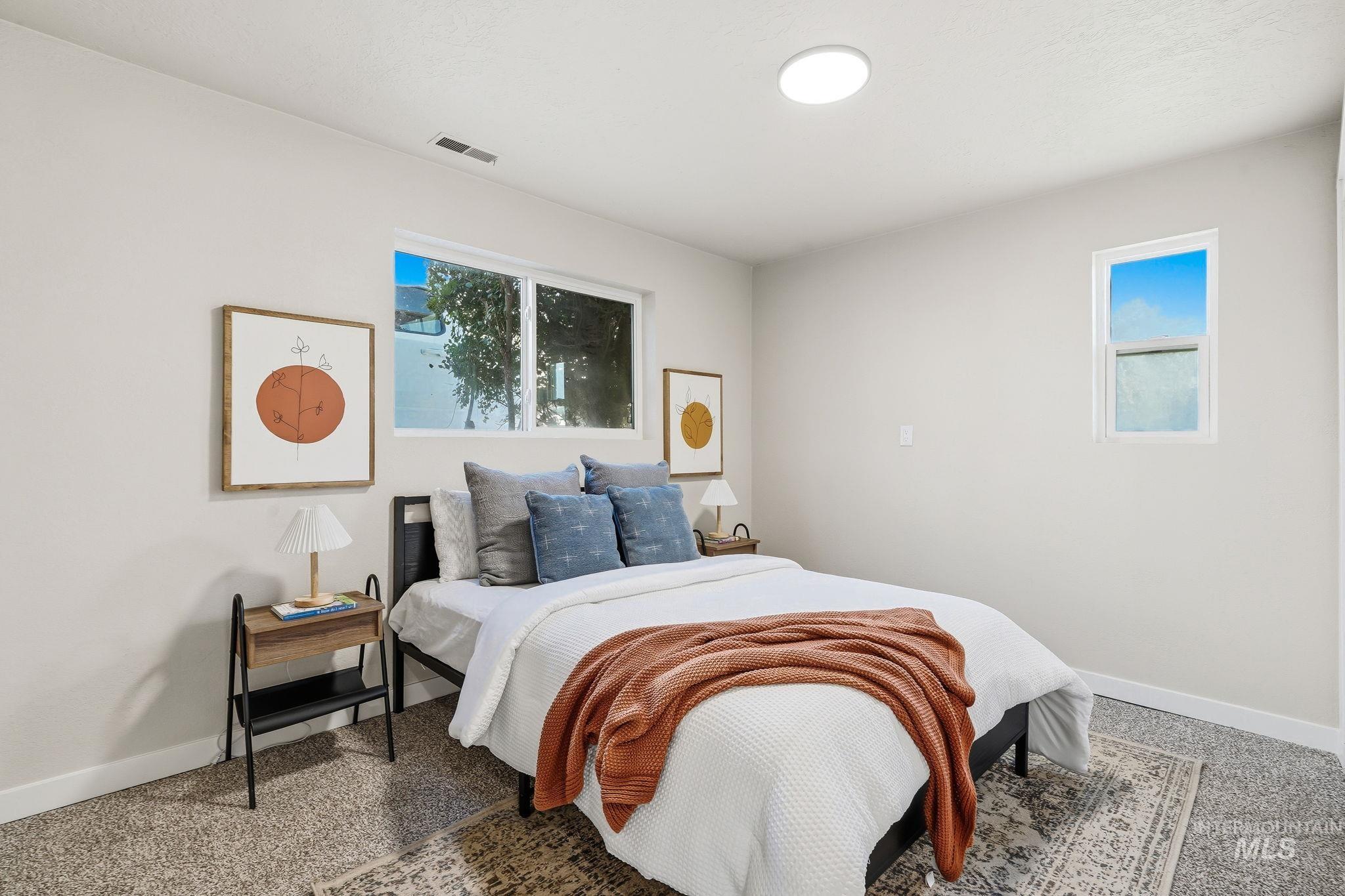 1990 Panama Street Boise, ID 83705 - Photo 37 of 50 Bedroom featuring light neutral wall paint, two windows with white trim, and a flush-mount ceiling light fixture
